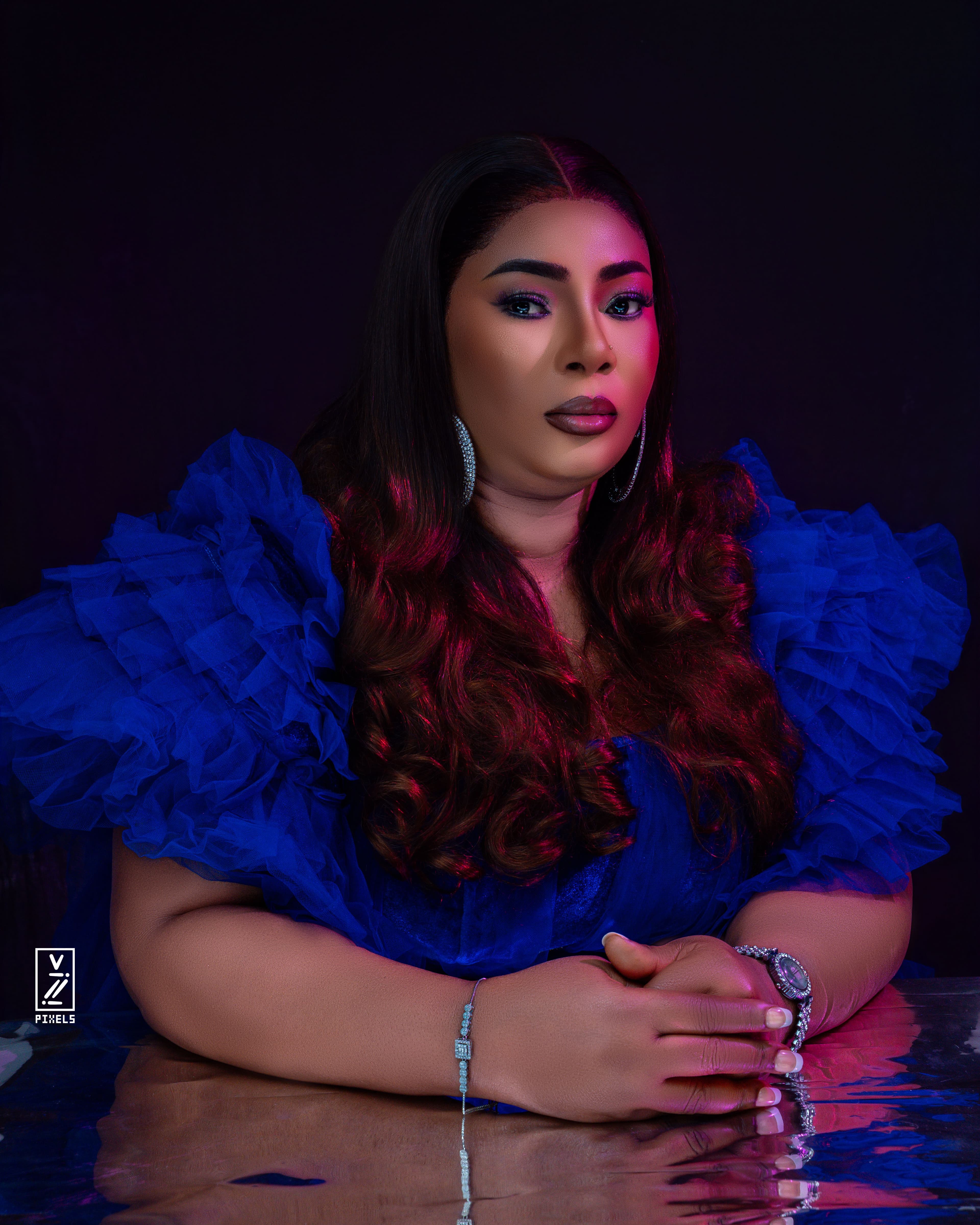 Studio portrait in a blue dress with magenta edge lighting